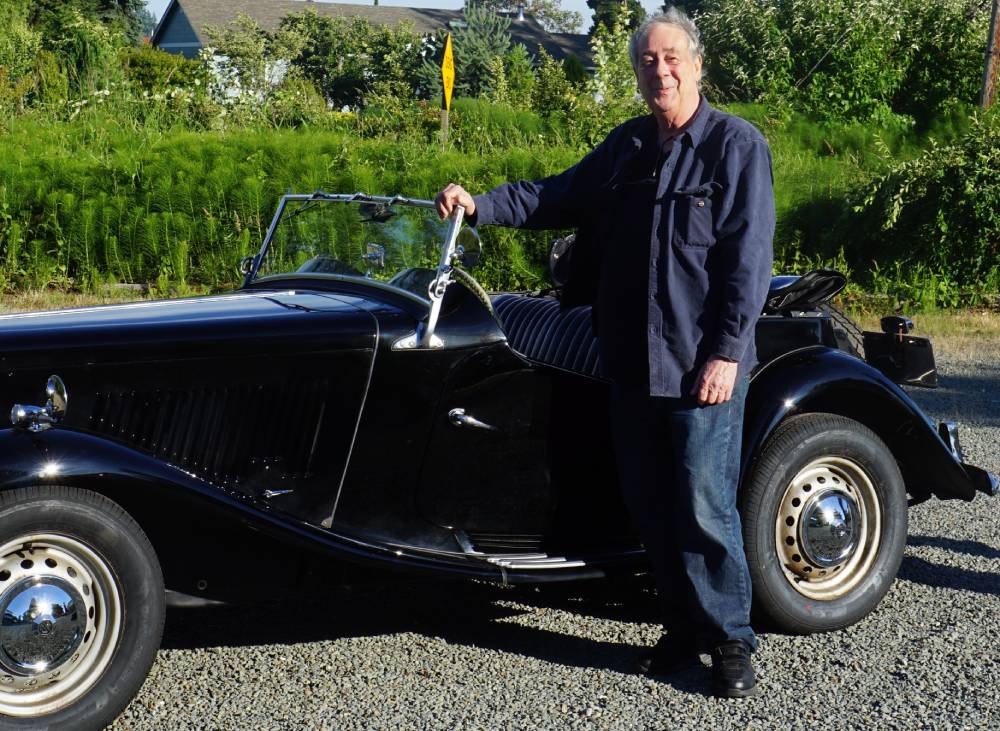 FL Decker standing next to his 1953 MGTD in a gravel parking lot